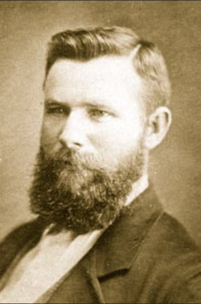 Studio portrait of Sergeant Michael Kennedy with swept back hair and a full beard